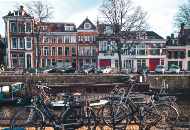Bicicletas paradas em frente a casas com arquitetura holandesa